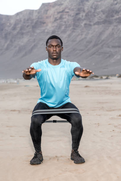 istock Black male athlete squatting on beach 1278974018