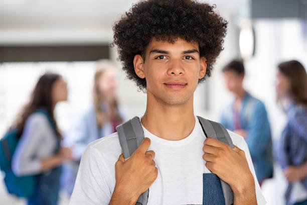 african guy standing with backpack in high school - adolescence teenager high school student teenagers only imagens e fotografias de stock