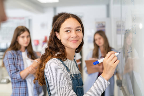smart student mädchen schreiben auf whiteboard - schoolgirl teenager teenage girls teenagers only stock-fotos und bilder