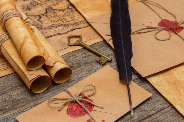 istock The surface of the old wooden table. On the table are old scrolls, an old map, an envelope with a seal, an iron key to the lock 1278975482