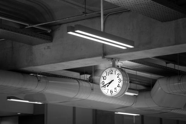 A classic round clock in airport or transportation building interior. Close-up and selective focus on the object. On time arrival concept photo.