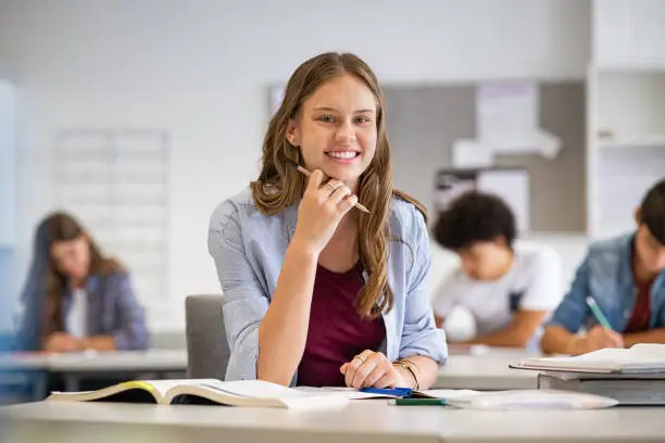 Photo of Happy smiling student girl studying in classroom