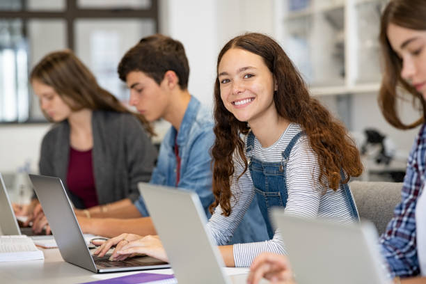 feliz chica de la escuela secundaria usando portátil en el aula - niño de escuela secundaria fotografías e imágenes de stock