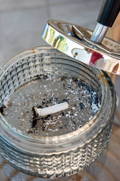 istock Single burned out cigarette butt in a large glass ashtray with metal top 1278976578