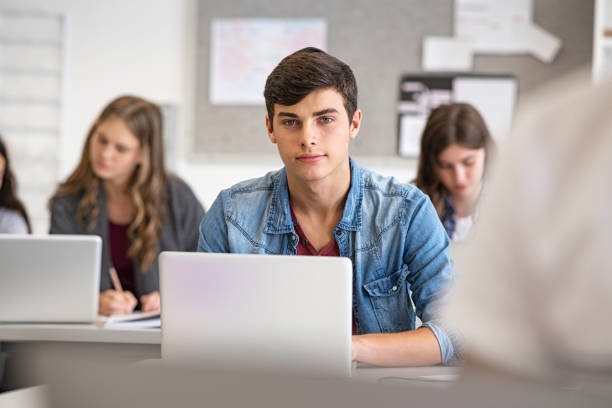 high school guy using laptop in classroom - teenager young men teenage boys portrait imagens e fotografias de stock