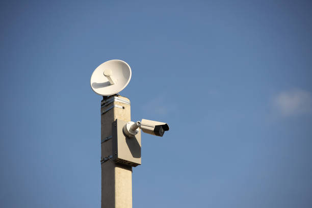 istock Surveillance system with an orange warning light located on a pole in the open. The threat of privacy and the protection of personal data. Security tracking on the streets of the city. Human mass 1278977317