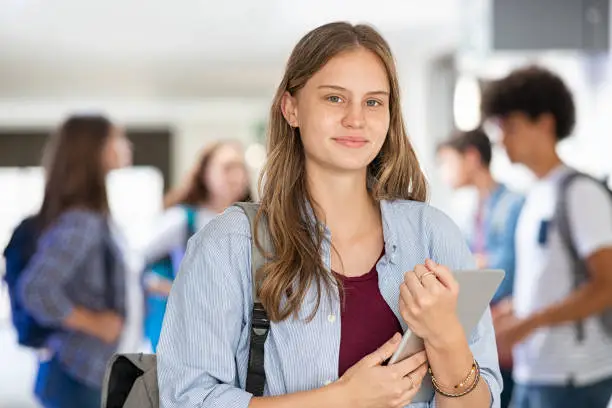 Photo of School girl holding digital tablet in college