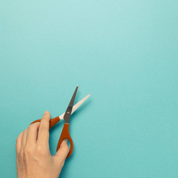 istock Scissors with hand on blue background. top view, copy space 1278979508