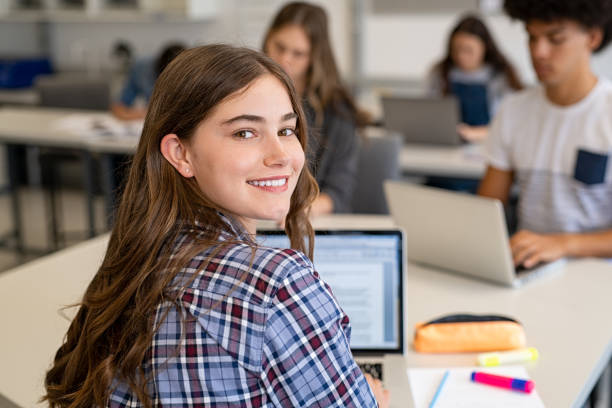 felice ragazza universitaria sorridente che studia su laptop - college student high school student education learning foto e immagini stock