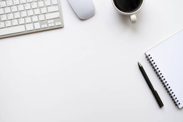 istock Top view above of White office desk table with keyboard, notebook and coffee cup with equipment other office supplies. Business and finance concept. Workplace, Flat lay with blank copy space. 1278979815