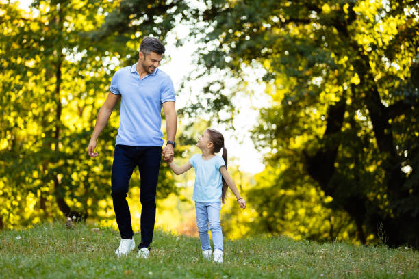 istock Father and daughter taking a walk in the park holding hands 1278981472