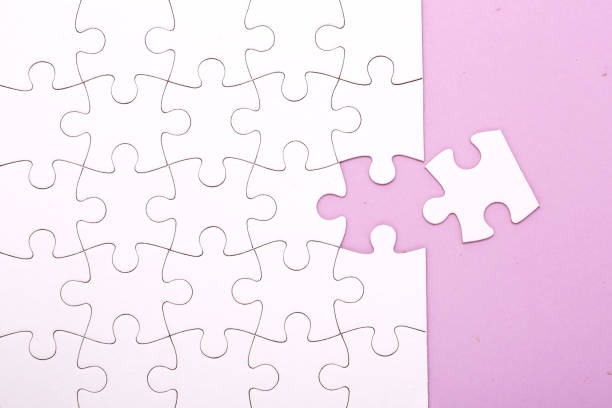istock White jigsaw puzzle pieces on lila background with copy space. 1278982921