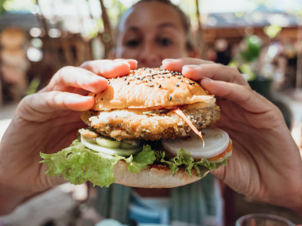 frau isst veganen burger in coolem café - freedom sandwich bread food stock-fotos und bilder