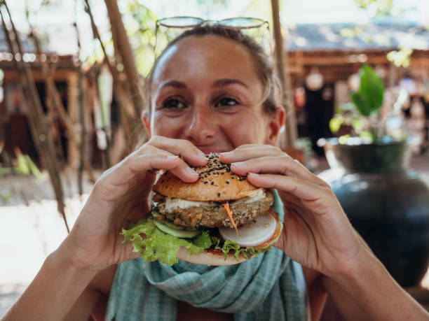 frau isst veganen burger in coolem café - freedom sandwich bread food stock-fotos und bilder