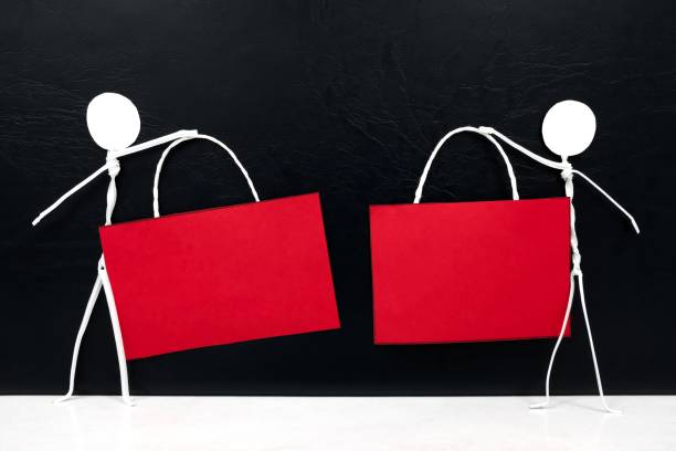 istock Stick man figure holding blank red signage template in dark background with copy space. Black friday sale and discount sign tag. 1278990107