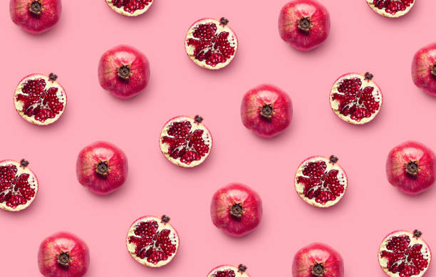 patrón de granadas frescas sobre fondo rosa - granada fruta tropical fotografías e imágenes de stock