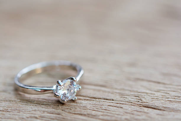 pierścionek z brylantem, obrączka na desce drewnianej - ring gold diamond engagement ring zdjęcia i obrazy z banku zdjęć