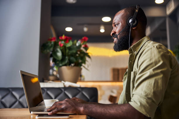 schöne afro-amerikaner in kopfhörer mit notebook im café - internet dating audio stock-fotos und bilder