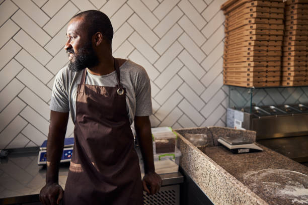 istock Cheerful young male baker working in pizzeria 1278994676