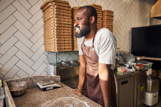 istock Cheerful man enjoying making pizza in cafe 1278994678