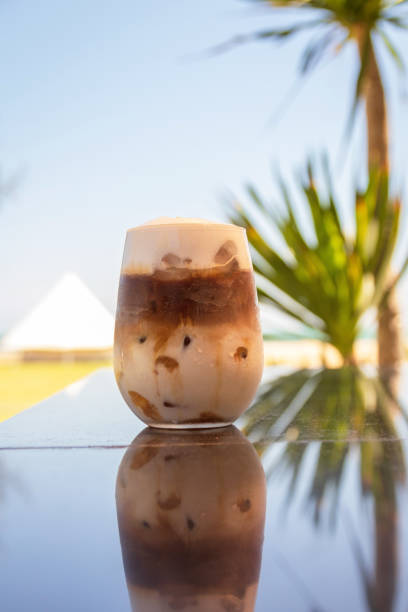 istock Iced coffee on counter bar on summer beach with pine tree and blue sky background. 1278995618