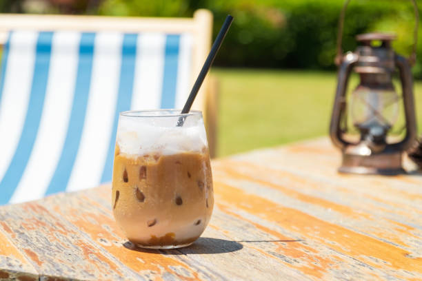 Iced coffee on wooden table on summer beach. stock photo