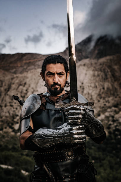 istock Black medieval knight with sword in front of a rocky landscape 1278997309