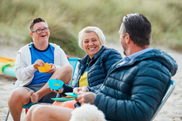 picknick-spaß - couple two parent family beach loving stock-fotos und bilder