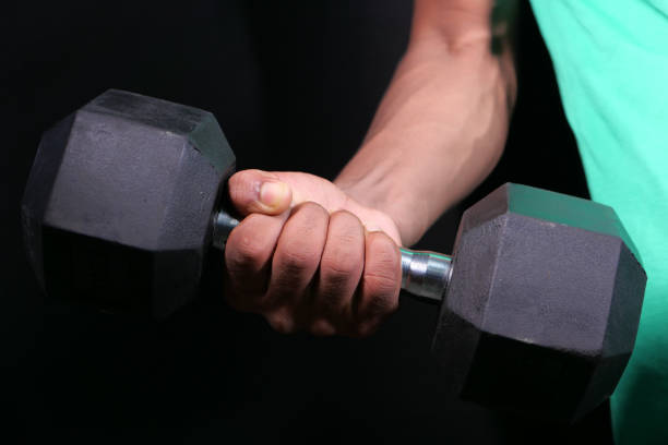 istock young man hand exercising with dumbbells indoor. 1279000457