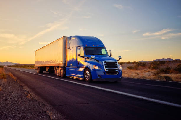 Long Haul Semi Truck On a Rural Western USA Interstate Highway Large semi truck hauling freight on the open highway in the western USA under an evening sky. semi truck photos stock pictures, royalty-free photos & images