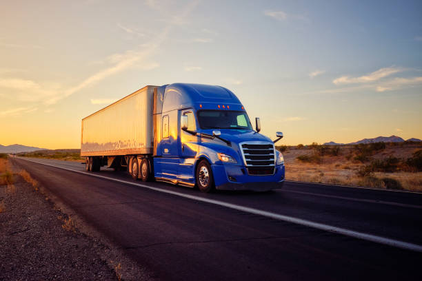 Long Haul Semi Truck On a Rural Western USA Interstate Highway Large semi truck hauling freight on the open highway in the western USA under an evening sky. american interstate stock pictures, royalty-free photos & images