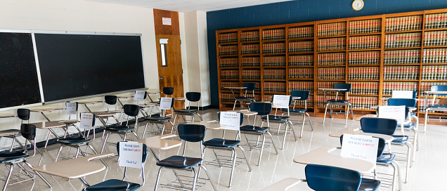 A high school classroom with papers on chairs that can not be sat in to help with social distancing and reopening the schools.