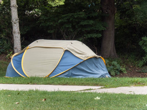 Homelessness is a social issue in many places Toronto, Canada; A homeless person's tent in a park in a residential area of Toronto allowed to remain by authorities to reduce the risk of spread of Covid-19 in homeless shelters barracks stock pictures, royalty-free photos & images
