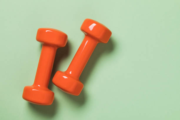 istock Orange dumbbells on green background, top view 1279004588