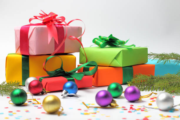 istock Christmas gifts with Christmas tree branches close-up on a white background with colored balls and confetti. 1279009959
