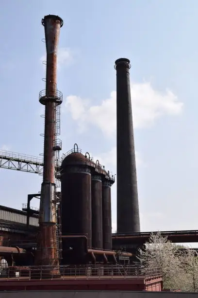 old industrial chimneys and rusty iron storage tanks of the former blast furnace complex Lapadu