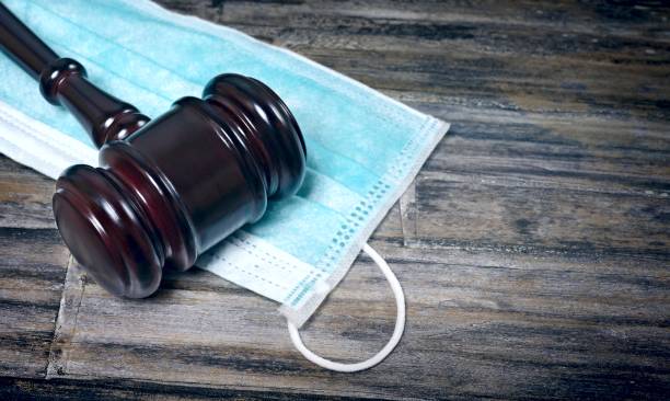 istock Gavel Resting On A Protective Mask on a wooden table. 1279010142
