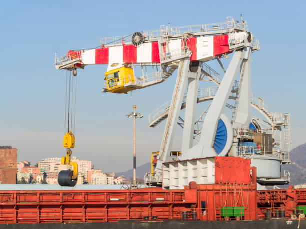 Genoa Italy: big port crane loading rolled steel sheet coil in a cargo ship