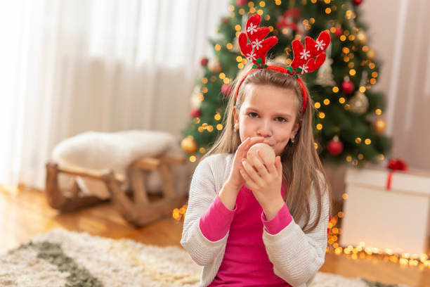 istock Kid blowing balloon while celebrating Christmas 1279012394