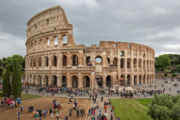 turistas visitando o coliseu (anfiteatro flávio) em roma - coliseum rome flavian roman - fotografias e filmes do acervo