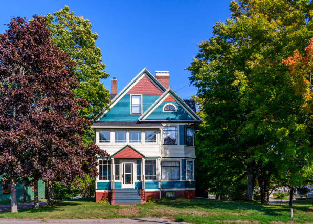 Parrsboro, Nova Scotia, Canada - September 24, 2020 : Beautiful house surrounded by trees starting to show some autumn foliage - Parrsboro, Nova Scotia, Canada.