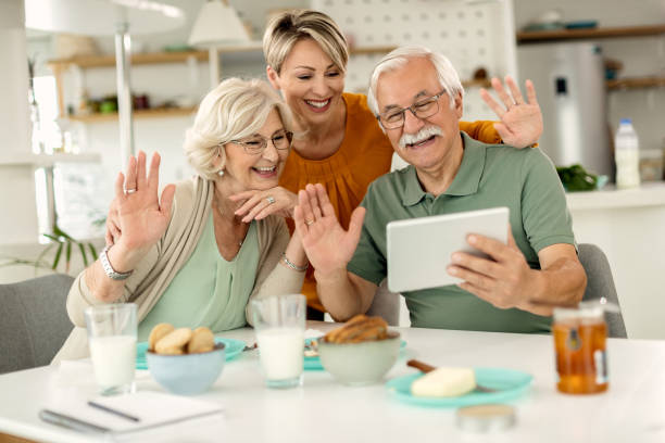 istock Cheerful family using touchpad and waving while making video call at home. 1279017721
