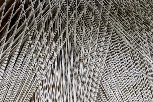 Photo of Close up texture of a lot of threads in a weaving machine called a loom