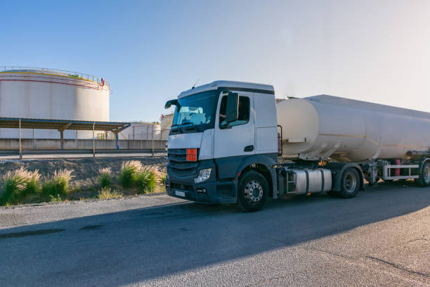 Fuel tanker next to the storage tanks Fuel tanker next to the storage tanks where the product to be transported is loaded. fuel truck photos stock pictures, royalty-free photos & images