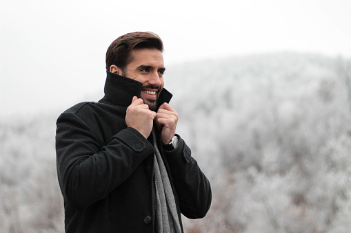 A handsome man looks forward to the first snow and a cold winter day