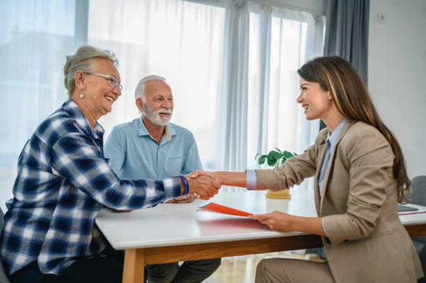 istock Senior couple shaking hands with financial advisor 1279039436