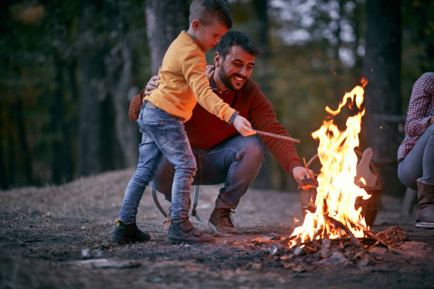 istock Father and son starting a fire; Quality family time concept 1279040438