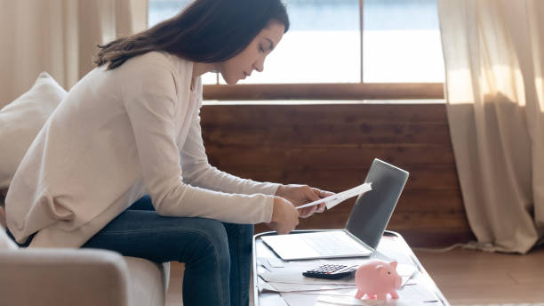 istock Concentrated young lady working with financial documents at home office 1279040714