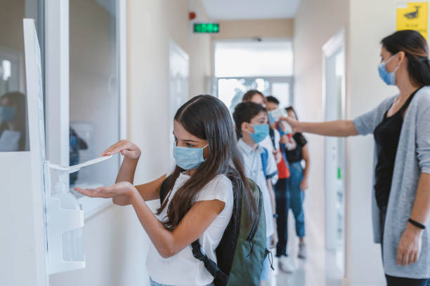 istock Little girl disinfecting hands while entering school. 1279041472