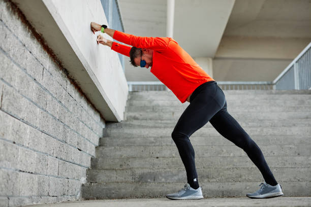 istock Middle aged handsome runner in shape doing warmup exercises on stairs. 1279045509